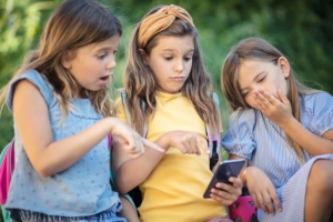 three kids on an iphone